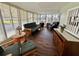 Bright sun room with a futon, armchairs, and many windows providing a view of the surrounding area at 114 Chestnut St, Leesburg, FL 34748