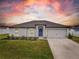 House exterior featuring a two-car garage and well-manicured lawn at 12018 Indian Grass Way, Leesburg, FL 34788