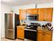 Modern kitchen with stainless steel appliances and wood cabinets at 123 Pyracantha Ln, Leesburg, FL 34748