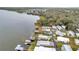 Aerial view of waterfront homes with boat docks on a serene lake surrounded by verdant trees at 13 Sunrise Trl, Fruitland Park, FL 34731
