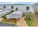 Aerial view of a home with a waterfront location, manicured lawns, a private dock, and mature trees at 13 Sunrise Trl, Fruitland Park, FL 34731