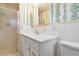 Clean bathroom with white vanity, shower, and floral wallpaper at 13 Sunrise Trl, Fruitland Park, FL 34731