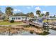 Picturesque waterfront home with inviting deck, boat dock, and lush landscaping, ideal for lakeside living at 13 Sunrise Trl, Fruitland Park, FL 34731