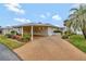 Charming single-story home featuring a covered carport, landscaped garden, and a well-maintained lawn at 13 Sunrise Trl, Fruitland Park, FL 34731
