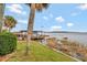 Scenic waterfront view showcasing a well-maintained lawn, lush greenery, and a private boat dock at 13 Sunrise Trl, Fruitland Park, FL 34731