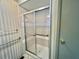 This bathroom features a tiled shower with a sliding glass door and chrome fixtures at 136 Dogwood Trl, Leesburg, FL 34748