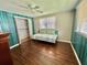 This bedroom features rich laminate flooring, a ceiling fan, and a comfortable daybed at 136 Dogwood Trl, Leesburg, FL 34748