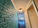 A hallway featuring a brick accent wall leading to a living space with natural light at 136 Dogwood Trl, Leesburg, FL 34748