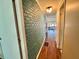 Hallway with decorative brick wall and wood flooring, enhancing the home's character at 136 Dogwood Trl, Leesburg, FL 34748