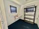 Bright laundry room with white walls, dark blue carpet, shelving, and a folding table at 136 Dogwood Trl, Leesburg, FL 34748