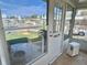 View from the sunroom showing the outdoors and entry door, with tile flooring and neutral decor at 136 Dogwood Trl, Leesburg, FL 34748