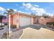 Light peach colored villa with a two car garage and American flag at 1504 Aalto Pl, The Villages, FL 32159