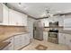 Modern kitchen with white cabinets, stainless steel appliances, and tile flooring at 1504 Aalto Pl, The Villages, FL 32159