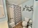 Bathroom featuring a toilet and tub-shower combo with grab bars and a patterned shower curtain at 169 Bougainvillea Dr, Leesburg, FL 34748