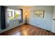 Cozy bedroom featuring light blue walls and hardwood floors with a large window at 169 Bougainvillea Dr, Leesburg, FL 34748