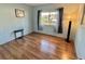 Bedroom with wood-look floors, a floor lamp, and a sunlit window with a view at 169 Bougainvillea Dr, Leesburg, FL 34748