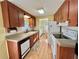 Kitchen with wood cabinets, laminate flooring, and white appliances at 169 Bougainvillea Dr, Leesburg, FL 34748