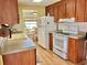 Galley kitchen with light countertops, wood cabinets, and white appliances at 169 Bougainvillea Dr, Leesburg, FL 34748