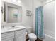 Simple bathroom with white vanity, shower/tub combo, and blue shower curtain at 17442 Blazing Star Cir, Clermont, FL 34714