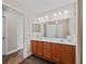 Bathroom featuring double sinks, wooden cabinets, a tile shower, and neutral wall paint at 17525 Se 121St Cir, Summerfield, FL 34491