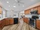 Well-lit kitchen featuring wood cabinets, granite countertops, and modern stainless steel appliances at 17525 Se 121St Cir, Summerfield, FL 34491