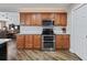 A well-equipped kitchen with stainless steel appliances, and wooden cabinets with a white backsplash at 17525 Se 121St Cir, Summerfield, FL 34491