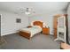 Spacious main bedroom featuring wooden furniture, a ceiling fan, carpeted floor, and natural light at 17525 Se 121St Cir, Summerfield, FL 34491