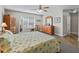 Spacious main bedroom featuring wooden furniture, a ceiling fan, carpeted floor, and natural light at 17525 Se 121St Cir, Summerfield, FL 34491