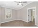 Bright bedroom with luxury vinyl plank flooring, neutral walls, a large shuttered window and white trim at 17760 Se 91St Gaylark Ave, The Villages, FL 32162