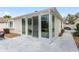 Exterior view of sunroom with large glass windows and sliding door opening onto a concrete patio at 17760 Se 91St Gaylark Ave, The Villages, FL 32162