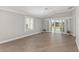 Bright living room with wood floors, sliding glass doors to a porch, and white trim at 17760 Se 91St Gaylark Ave, The Villages, FL 32162