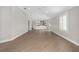 Open-concept living room with wood floors and views of the modern white kitchen at 17760 Se 91St Gaylark Ave, The Villages, FL 32162