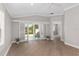 Living room with wood floors, white trim, and glass doors leading to an outdoor space at 17760 Se 91St Gaylark Ave, The Villages, FL 32162