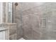 Shower features decorative tile accent and seamless glass door for a modern, luxurious experience at 17760 Se 91St Gaylark Ave, The Villages, FL 32162