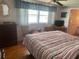 Bright bedroom with striped bedding, wood floors, and large windows at 185 Jacaranda Dr, Leesburg, FL 34748