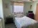 Cozy bedroom with double bed and window coverings at 185 Jacaranda Dr, Leesburg, FL 34748