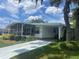 White single-wide home with carport and screened porch at 185 Jacaranda Dr, Leesburg, FL 34748