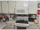 Bright kitchen with white cabinets, electric cooktop, and microwave at 185 Jacaranda Dr, Leesburg, FL 34748