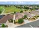 Stunning aerial view of houses on a golf course community surrounded by lush greenery and well-manicured lawns at 1941 Loadstar Ave, The Villages, FL 32162