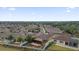 Scenic aerial view of a suburban neighborhood showcases many homes with lush greenery and palm trees at 1941 Loadstar Ave, The Villages, FL 32162