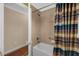 Clean bathroom with tub, shower, and striped shower curtain at 1941 Loadstar Ave, The Villages, FL 32162