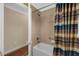 Bright bathroom showcases tile walls, a white shower and bathtub combo, with a multi-striped curtain at 1941 Loadstar Ave, The Villages, FL 32162