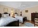 Inviting bedroom features two twin beds, ceiling fan, and dark-wood furniture with beautiful hardwood floors at 1941 Loadstar Ave, The Villages, FL 32162