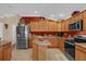 L-shaped kitchen with stainless steel appliances and wood cabinets at 1941 Loadstar Ave, The Villages, FL 32162