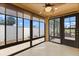 The sunroom features tile flooring, large windows, and a ceiling fan for comfort and natural light at 1941 Loadstar Ave, The Villages, FL 32162