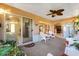 Relaxing screened porch with white wicker furniture, ceiling fan and view into the house at 2043 Sawgrass Dr, Apopka, FL 32712