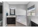 Bathroom with corner bathtub, dark vanity, and mosaic accents at 2064 Lula Rd, Minneola, FL 34715