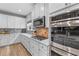 Modern kitchen with white cabinets, stainless steel appliances and hexagon tile backsplash at 2064 Lula Rd, Minneola, FL 34715