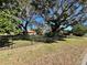 Landscaped yard with large oak trees and fence at 208 First St, Tavares, FL 32778