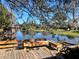 Relaxing waterfront deck with wooden benches overlooking a peaceful lake at 208 First St, Tavares, FL 32778